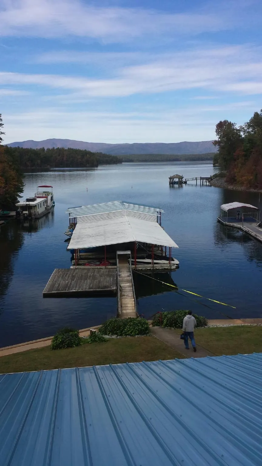 View across a lake from a newly installed blue metal roof in Franklin